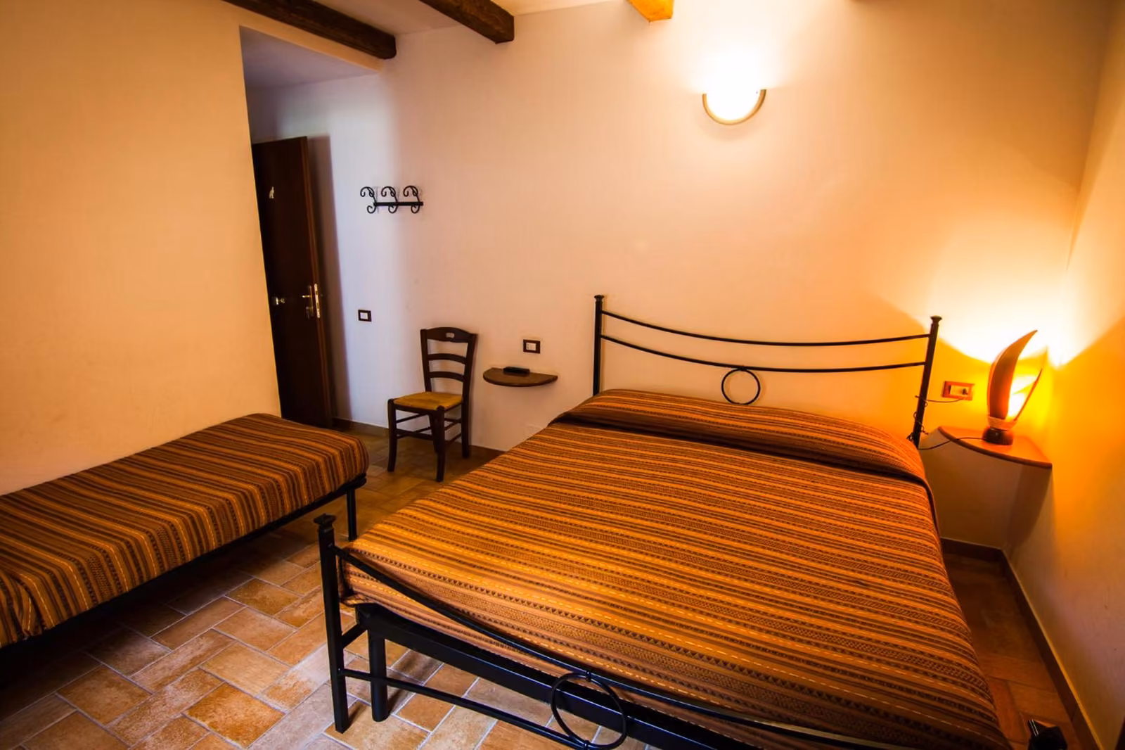 Una camera dell'agriturismo con letto matrimoniale e arredi in legno
